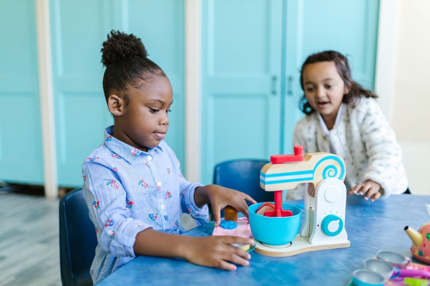 Children learning and playing together in a bright, clean childcare room